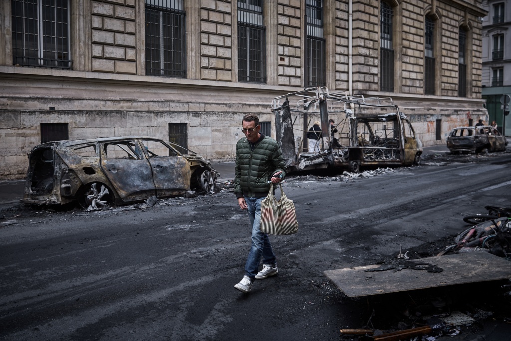 Burnt-out vehicles line a Paris street on Monday — Kiran RIDLEY / AFP