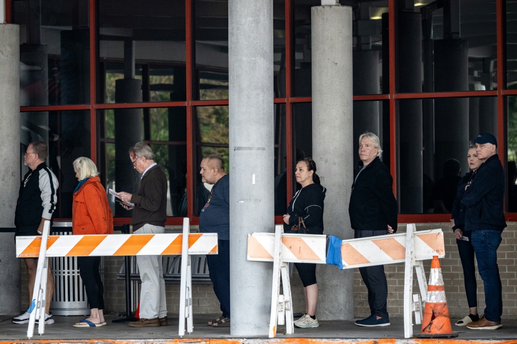 People wait in line at a polling location on the first day of early voting in Houston, Texas — RONALDO SCHEMIDT / AFP