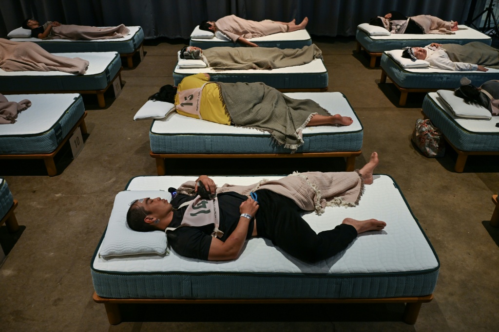 The Tokyo competition, dubbed "Matt Race", saw dozens of participants fitted with sleep tracking devices sprawl on comfy mattresses to slumber for up to 90 minutes — Selim CHTAYTI / AFP