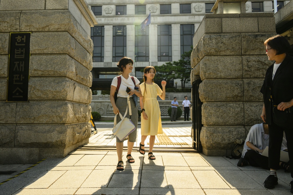 Young climate activist Han Jeah and her mother, Kim Eun-jae, celebrate outside South Korea's Constitutional Court after their victory in August 2024, which forced the government to set new targets for reducing greenhouse gas emissions — ANTHONY WALLACE / AFP