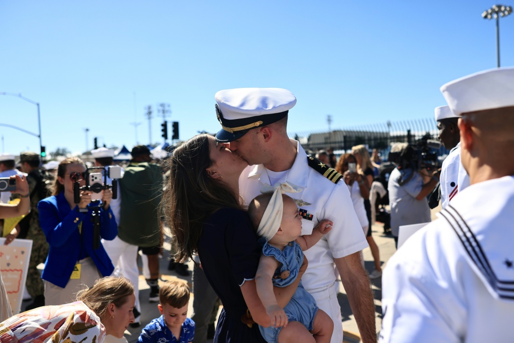 More than 100 new dads stepped ashore in San Diego to meet babies that were not born when they left port almost a year ago. — David Swanson / AFP