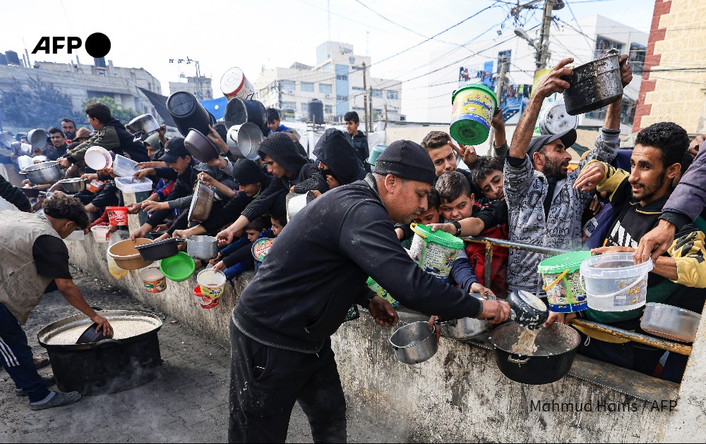 Des Palestiniens attendent de recevoir de la nourriture à un point de collecte dans un camp de réfugiés à Rafah, dans le sud de la bande de Gaza, le 23 décembre 2023.