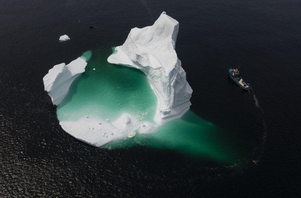 Esta foto aérea muestra el barco del Capitán Edward Kean pasando un iceberg en la Bahía de Bonavista el 29 de junio de 2019 en Newfoundland, Canadá. Johannes Eisele / AFP