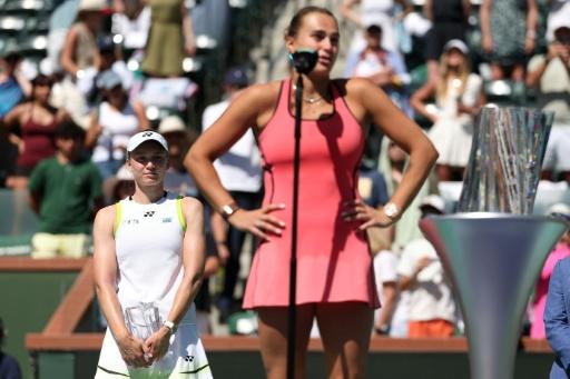 La Kazakhe Elena Rybakina, finaliste malheureuse, observe la Bélarusse Aryna Sabalenka s'adresser au public après sa victoire en finale du simple dames, à Indian Wells (Californie), le 15 mars 2026 — CLIVE BRUNSKILL