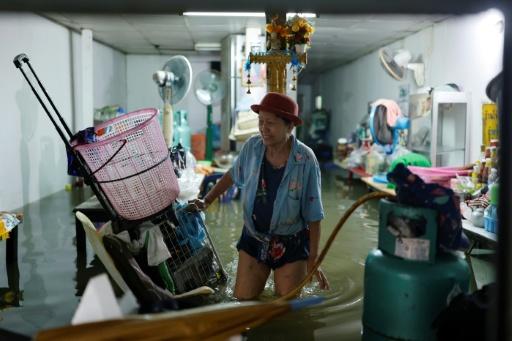 A person wades through floodwaters in the Bang Bua district of Bangkok on September 26, 2026. — WIKUS DE WET / AFP