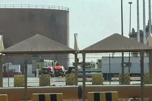 Capture d'écran tirée d'une vidéo d'AFPTV prise le 19 septembre 2026 montrant des camions de pompiers et des véhicules de police sur les lieux d'un incendie au dépôt de carburant d'Aramco, près de l'aéroport international de Ryad — - / AFP