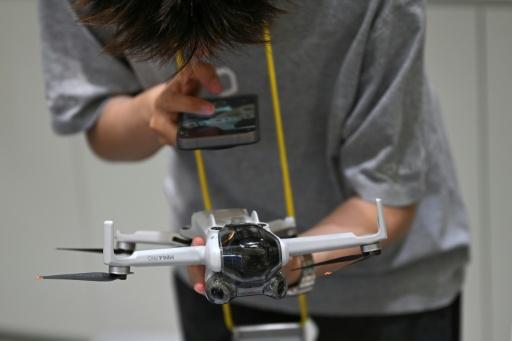 Un employé d’un point de rachat de drones, installé dans un centre commercial de Pékin, inspecte un appareil apporté par son propriétaire, le 16 septembre 2026. — Pedro PARDO / AFP