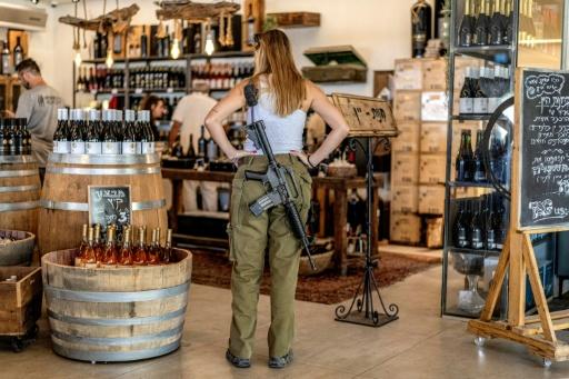 Une soldate de l'armée israélienne regarde des bouteilles de vin en vente dans une exploitation viticole de la colonie israélienne de Shaar Binyamin, au sud-est de Ramallah, le 9 septembre 2026 en Cisjordanie occupée — Ilia YEFIMOVICH / AFP