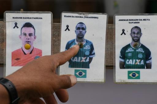 A Colombian who helped rescue survivors from the plane crash that wiped out the Brazilian football team Chapecoense in 2016 points to pictures of the victims — Jaime SALDARRIAGA / AFP