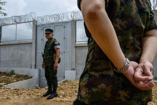 Le capitaine Prachya Hantiem (g), commandant d'une force de la Marine royale, devant un mur en béton installé par l'armée thaïlandaise à la frontière entre la Thaïlande et le Cambodge, dans le district de Pong Nam Ron, le 10 septembre 2026 en Thaïlande — ANTHONY WALLACE / AFP