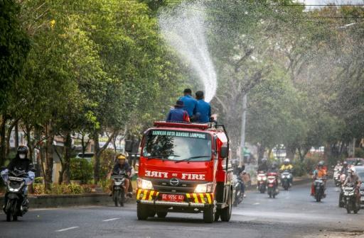 Des pompiers projettent de l'eau dans une rue pour évacuer les cendres provoquées par l'éruption du volcan Anak Krakatoa à Bandar Lampung, le 6 septembre 2026 en Indonésie — PERDIANSYAH / AFP