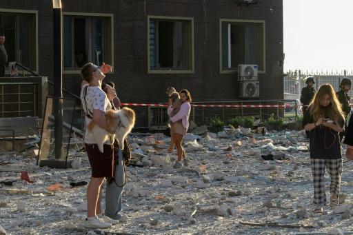 Des habitants se tiennent à l'extérieur d'un immeuble d'habitation endommagé par des frappes de missiles et de drones russes sur la ville portuaire ukrainienne d'Odessa, le 12 septembre 2026 — Oleksandr GIMANOV / AFP
