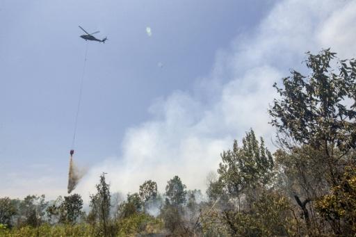 Un hélicoptère largue de l’eau sur des forêts et des terres en feu dans les zones de Tegal Arum et Guntung Damar, à Banjarbaru, dans la province de Kalimantan du Sud, en Indonésie, le 19 septembre 2026 — MUDA SAGALA / AFP