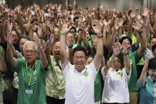 Genta Koja (front centre) celebrates with his supporters after winning the Okinawa gubernatorial election in Naha, Okinawa — STR / AFP