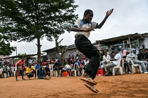 Un jeune homme fait une démonstration de biama, à Abidjan, le 19 août 2026 — Issouf SANOGO / AFP