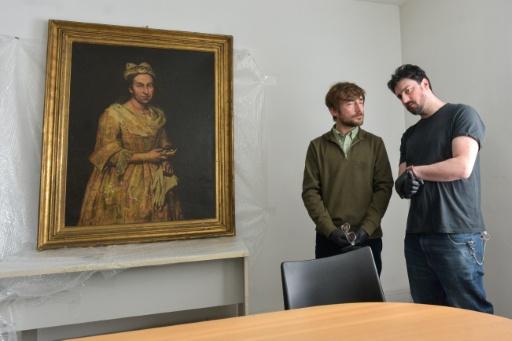 Le professeur d'arts plastiques Ariel Bassano (g) près d'un tableau identifié comme le "Portrait d'une dame" de l'Italien Giacomo Ceruti à Mar del Plata, en Argentine, le 3 septembre 2025 — STRINGER / AFP