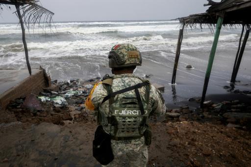 A Mexican soldier stands guard along the shoreline as strong waves churn the waters off Lazaro Cardenas, Mexico, as Hurricane Polo strengthened to a Category 5 storm — Enrique Castro / AFP