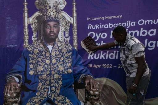Une personne nettoie une affiche du défunt roi ougandais Oyo Nyimba Kabamba Iguru Rukidi IV au terrain de Humura, à Kyegegwa (Ouganda), le 4 septembre 2026 — Badru KATUMBA / AFP