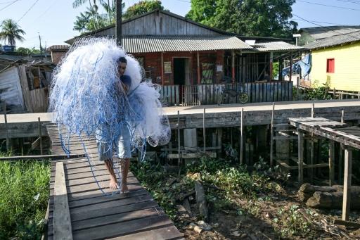 Um pescador carrega uma rede em Oiapoque, estado do Amapá — Nelson ALMEIDA / AFP