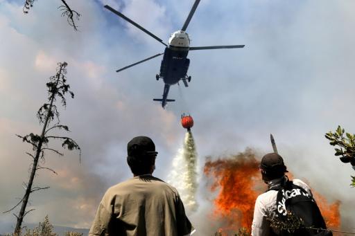 A helicopter drops water on a forest fire in central Colombia — LUIS LIZARAZO / AFP