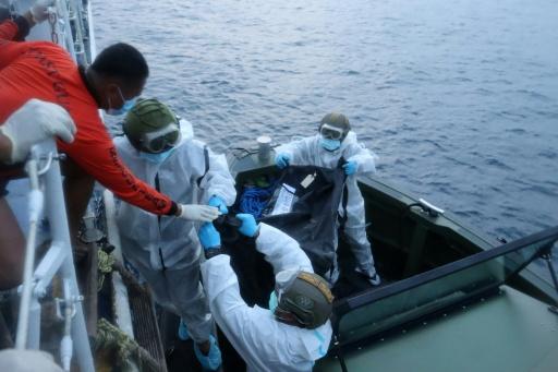 Recovery personnel loading bags with the bodies of people killed in the M/V June Aster blaze — Handout / AFP