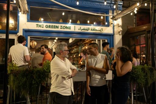 Iranian journalist Mohammad Reza Mousavi (L) spends time with Iranian friends outside The Green Zone in Washington, DC, on September 6, 2026 — Amid FARAHI / AFP